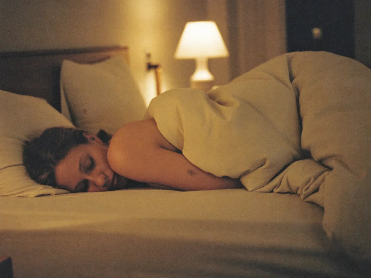 Woman asleep in bed in a softly lit bedroom