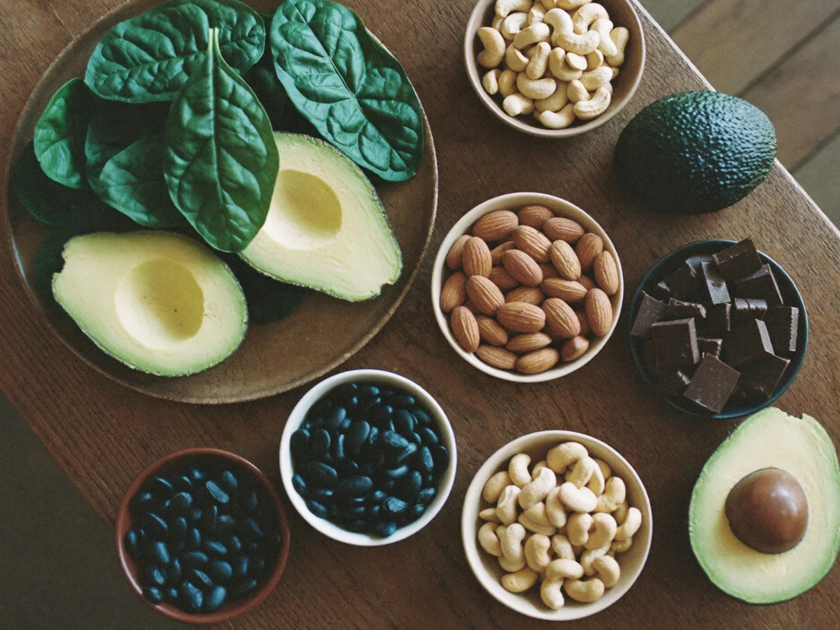 Table of magnesium-rich foods including spinach, nuts, seeds, avocado, beans and dark chocolate